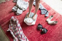 Pernas de mulher jovem despida em pé em balanças de pesagem — Fotografia de Stock