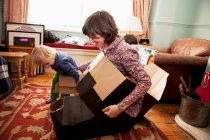 Madre e figlio che giocano con scatole di cartone in soggiorno — Foto stock