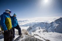 Dos snowboarders masculinos mirando hacia fuera sobre paisaje nevado, Trient, Alpes suizos, Suiza - foto de stock
