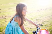 Young girl riding bike in summer — Stock Photo