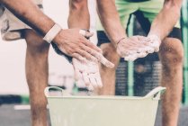 Cropped shot of two male cross trainers chalking hands in gym — Stock Photo
