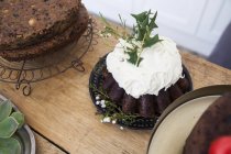 Gâteaux sur le comptoir de la cuisine, un décoré avec glaçage et feuilles — Photo de stock