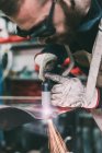 Metalworker plasma-cutting copper in forge workshop — Stock Photo