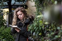 Woman in street reading book, Milan, Italy — Stock Photo