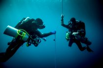 Підводний вид двох технічних водолазів, які використовують пристрої для рециркуляції, щоб знайти корабельну аварію, Ломбок, Індонезія. — стокове фото