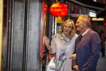 Mature dating couple reading restaurant menu in China Town, London, UK — Stock Photo