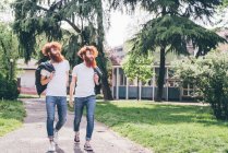 Young male hipster twins with red beards strolling in park — Stock Photo