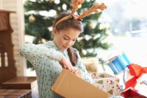 Mädchen eröffnet Geschenk am ersten Weihnachtsfeiertag — Stockfoto