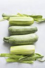 Due zucchine intere e due pelate, vista dall'alto — Foto stock