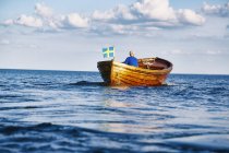 Homem sênior navegando em barco no oceano azul — Fotografia de Stock