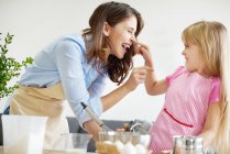 Madre e figlia cuocere insieme, scherzare in giro — Foto stock
