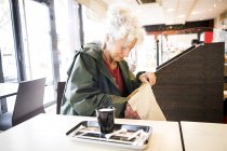 Woman in cafe searching bag — Stock Photo