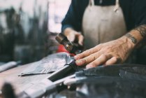 Hände eines Metallarbeiters hämmern Bleimetall in Schmiedewerkstatt — Stockfoto