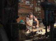 Bootsbauer schleift Holz in Werkstatt — Stockfoto