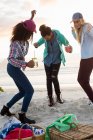 Trois jeunes amies dansent au pique-nique à la plage, Cape Town, Western Cape, Afrique du Sud — Photo de stock
