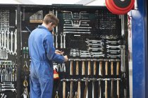 Студент коледжу механіки вибирає ключ від ремонту комплекту інструментів гаража — стокове фото