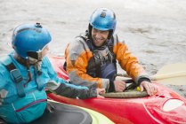 Male and female kayakers talking on River Dee — Stock Photo