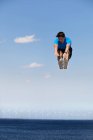 Hombre saltando de alegría sobre turbinas eólicas - foto de stock