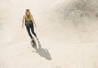 Angolo alto di giovane skateboarder femminile skateboard in skatepark — Foto stock