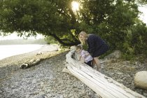 Хлопчик з матір'ю сходження на стовбур дерева на озері Онтаріо, Ошава, Сполучені Штати Америки — стокове фото