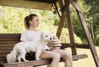 Женщина, сидящая на качалке с котон-де-тулеров собака, Оривеси, Финляндия — стоковое фото
