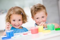 Menina e menino brincando com cores — Fotografia de Stock