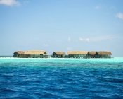 Moradias aquáticas acima do oceano azul-turquesa, Maldivas — Fotografia de Stock