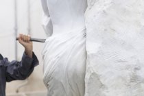 Каменщик, использующий стамеску и молоток для создания скульптуры — стоковое фото
