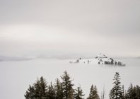 Snow capped mountain in fog — Stock Photo