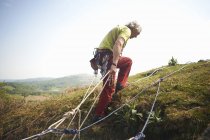 Скелястий альпініст на схилі пагорба готує скелелазіння — стокове фото