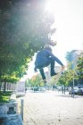 Молодий чоловік скейтбордист робить стрибок у скейтборді на тротуарі — стокове фото