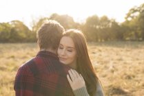 Jovem casal em ambiente rural, abraçando — Fotografia de Stock