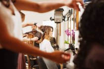 Clientes do sexo feminino com seu cabelo estilizado no salão de cabeleireiro — Fotografia de Stock