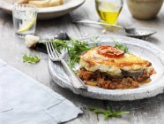 Portion of vegetable moussaka on plate with fork — Stock Photo