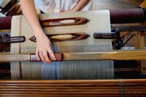 Hands of young woman using loom — Stock Photo