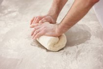 Cropped image of Chef kneading dough in kitchen — Stock Photo