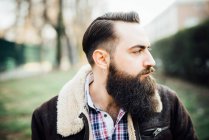 Молодой бородатый человек в парке — стоковое фото