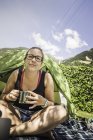 Mujer acampando, mirando a la cámara sonriendo, Merano, Tirol del Sur, Italia - foto de stock