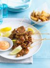 Plate of chicken skewers with sauce — Stock Photo