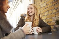Zwei junge Frauen trinken Kaffee im Freien — Stockfoto