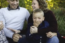 Familie umarmt und lächelt gemeinsam draußen — Stockfoto
