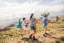 Adolescente y amigos adultos jóvenes caminando en las colinas, Bridger, Montana, EE.UU. - foto de stock