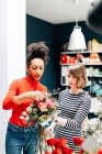 Deux femmes faisant bouquet dans la boutique de fleuristes — Photo de stock