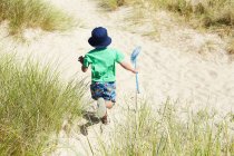 Хлопчик несе рибальську сітку на пляжі — стокове фото