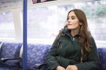 Женщина в поезде смотрит в сторону — стоковое фото