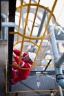 Worker climbing ladder at oil refinery — Stock Photo