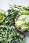 Close up of green vegetables and herbs on counter — Stock Photo