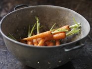 Fresh organic vegetables, baby carrots in metal colander — Stock Photo