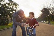 Nonno insegnare nipote ad andare in bicicletta nel parco — Foto stock