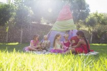 Five girls playing with teddy bears in front of teepee — Stock Photo